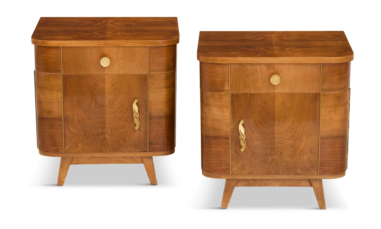 Pair of Art Deco Bedside Commodes: Pair of Art Deco Bedside Commodesca. 1940s, the olivewood-veneered commodes with rounded sides, set with a drawer over a lower cabinet, with pierced gilt-brass Art Deco pulls, on angled legs.h. 21-1/2
