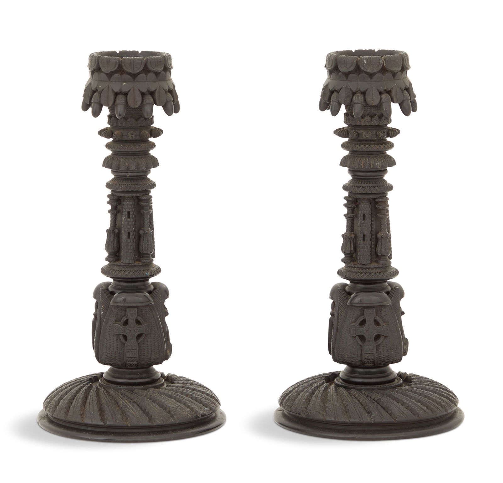 Pair of Irish Carved Bog Oak Candlesticks: Pair of Irish Carved Bog Oak Candlestickslate 19th century, the candle cups carved with acorns, over standards carved with towers, lyres and Celtic crosses, over spiral-carved feet.h. 10-1/4", dia. 5"