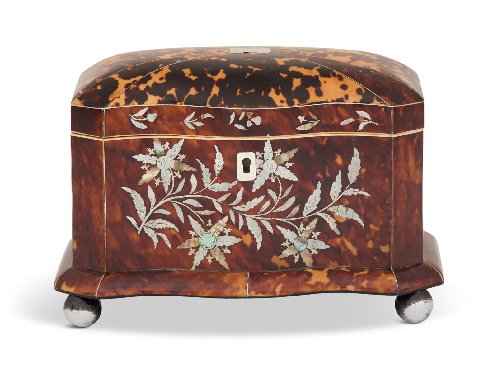 English Mother-of-Pearl Tea Caddy: English Mother-of-Pearl Tea Caddyca. 1840, the serpentine front inlaid with sprays of mother-of-pearl leaves and flowers, the two-compartment interior with covers and remnants of foil lining.h. 5-1/4"