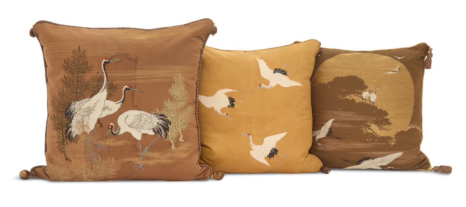 Three Custom Silk Pillows in the Japanese Taste: Three Custom Silk Pillows in the Japanese Tasteeach decorated with cranes, with braided trim and various corner tassels, one on a gold ground and two on a chocolate brown ground.w. 18-1/2" to 20", l.