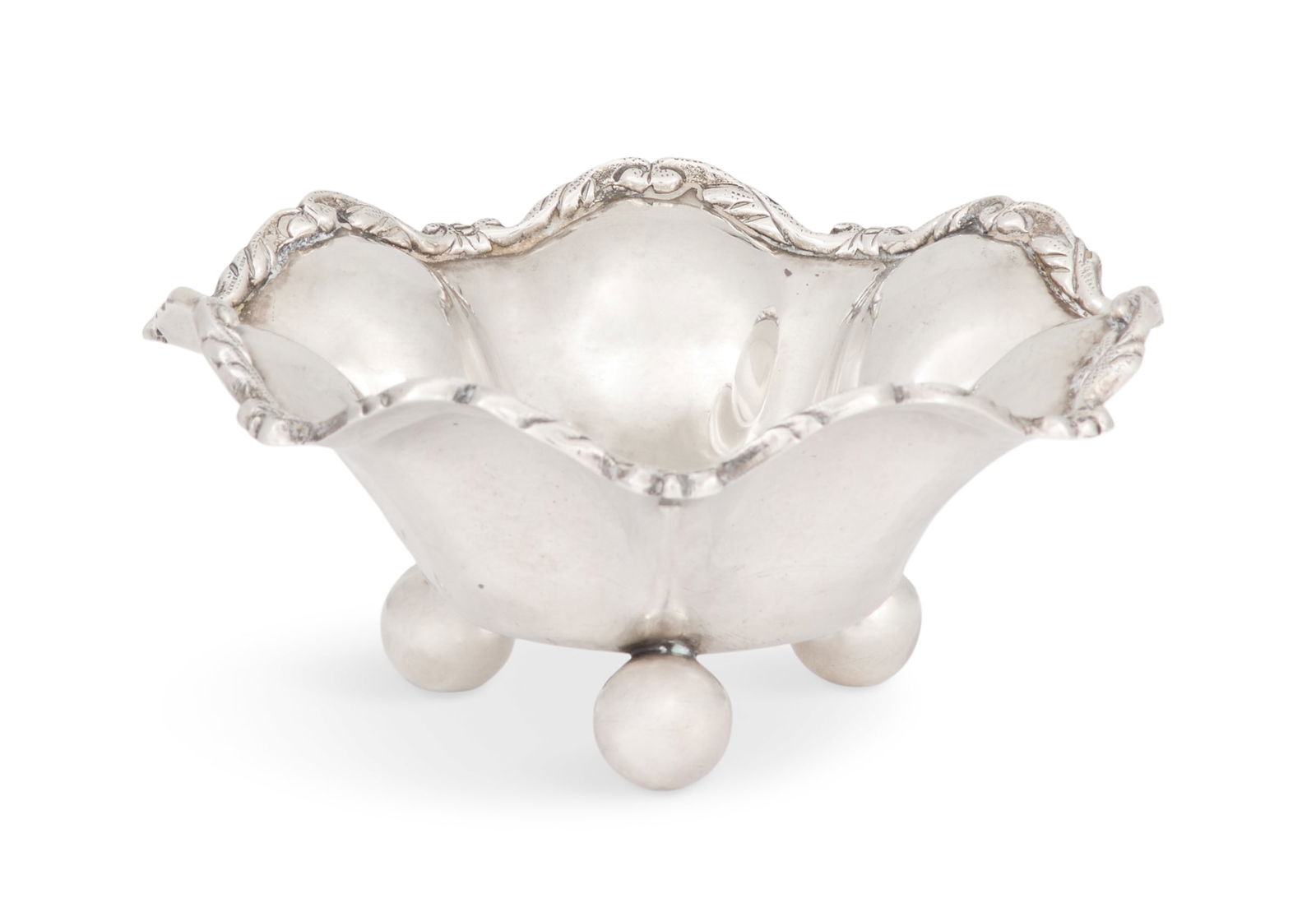 Mexican Sterling Silver Condiment Dish: Mexican Sterling Silver Condiment Dishlate 20th century, of lobed circular form with applied foliate scroll rim and raised on three spherical feet.h. 2-1/2", dia. 5-3/4"; 7.01 t. oz. Provenance: The E