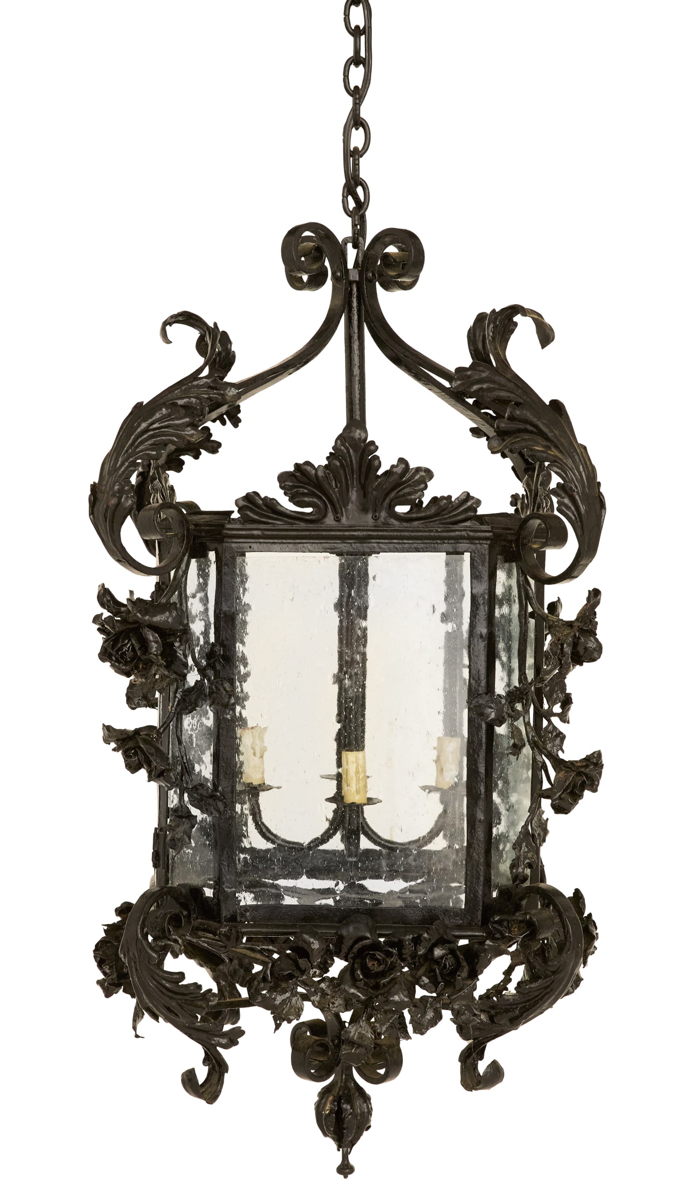 Large Continental Black Metal Lantern: Large Continental Black Metal Lanternthe rectangular lantern with faceted corners, supported on a scrolled frame ornamented with leaves, the lantern set with "bubble" glass panes, with molded flowers