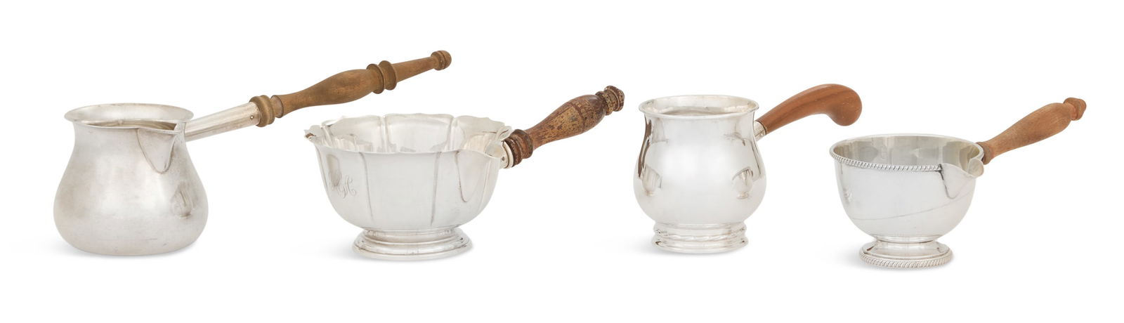 Four Colonial Revival Sterling Silver Brandy Pans: Four American Colonial Revival Sterling Silver Brandy Pansmid-20th century, each with turned or carved wood handle, including:an F.B. Rogers Co. example with hemispherical bowl and gadrooned banding,