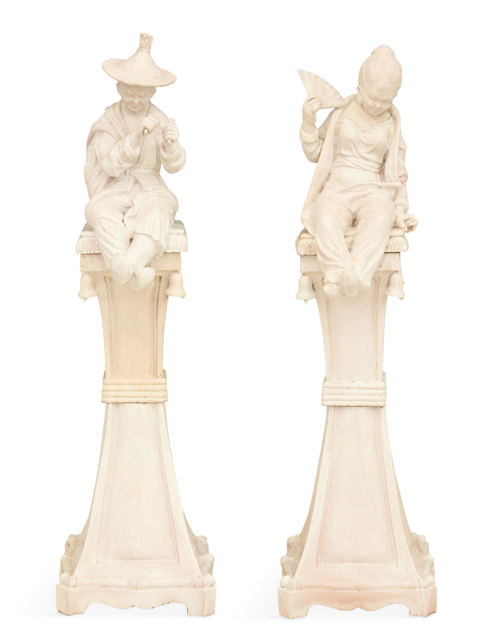 Italian Faience Chinoiserie Couple on Pedestals: Italian Faience Chinoiserie Couple on Pedestalsthird quarter 20th century, both seated in traditional attire, the woman holding a fan and the man playing the paiban, on a fringed cushion with molded t