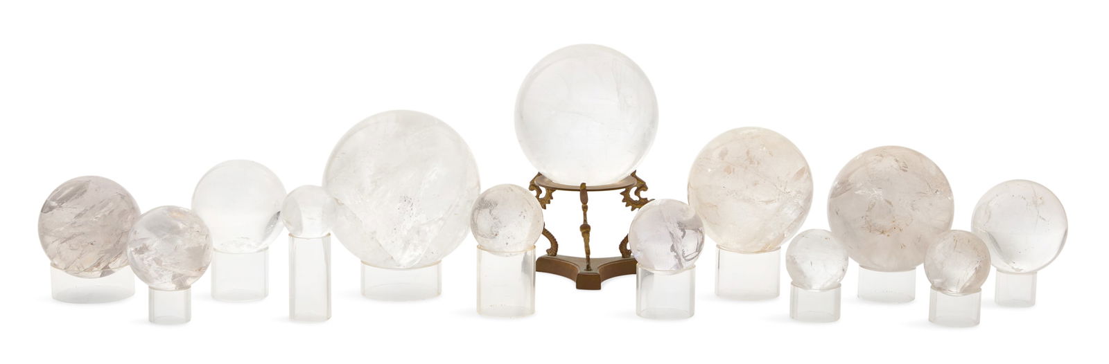 Collection of Thirteen Rock Crystal Spheres: Collection of Thirteen Rock Crystal Spheresone supported on a tripartite bronze base with dragon-form legs and the others on cylindrical stands.h. 2-1/2" to 7-1/2", dia. 1-1/2" to 4-1/4" Provenance: T