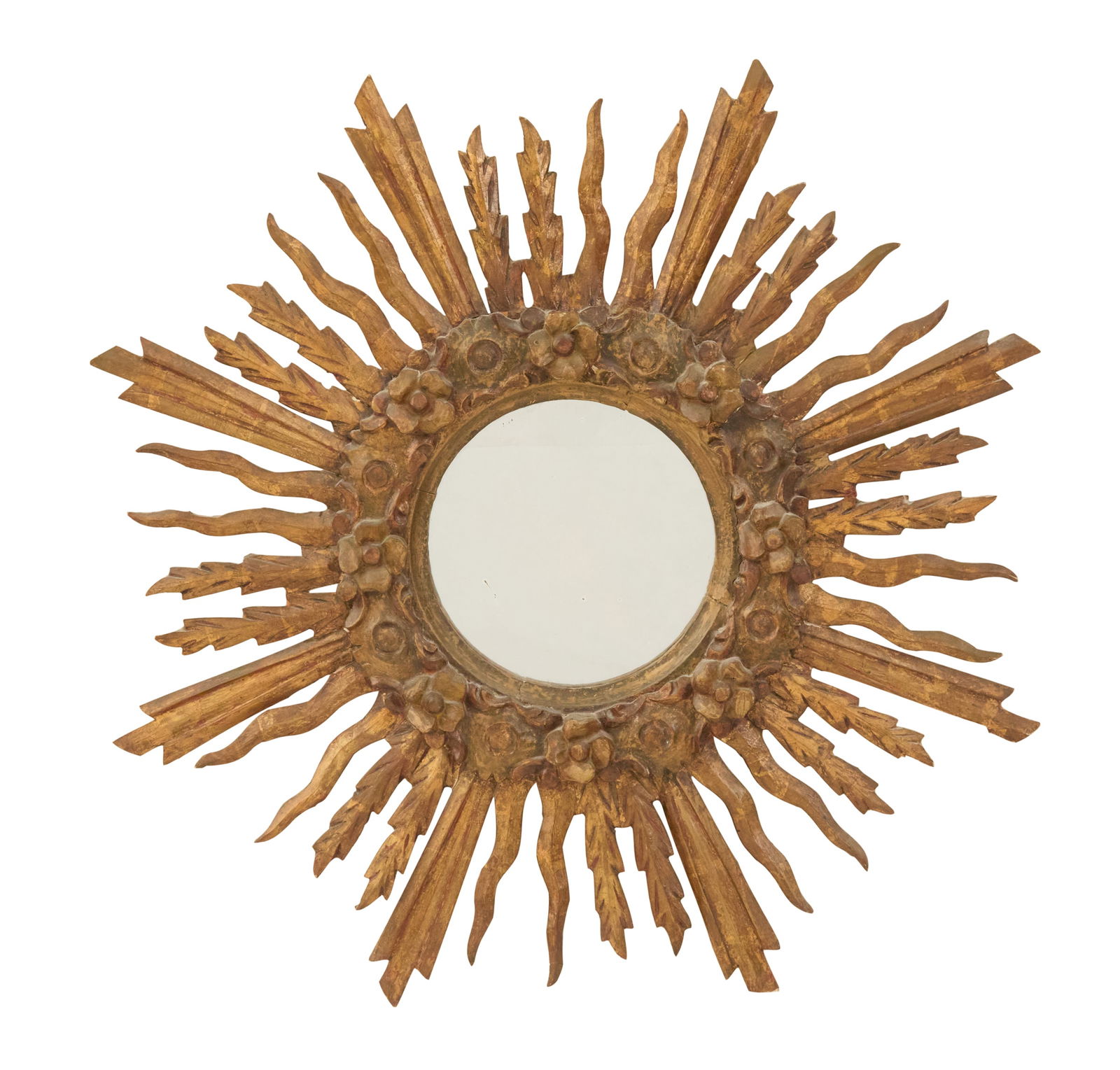 Latin American Giltwood Sunburst Mirror: Latin American Giltwood Sunburst Mirror 20th century, set with a circular flat mirror plate, the wide surround carved with flower heads and scrollwork, a variety of carved "rays" emanating from the