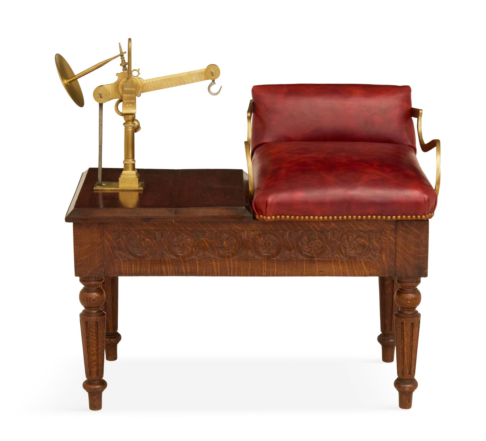 English Oak and Leather-Covered Jockey Scale: English Oak and Leather-Covered Jockey Scaleca. 1900, of bench form with a red leather seat and brass mounts, with a balance scale to one side, on a carved frame, raise on turned and fluted legs.h. 29