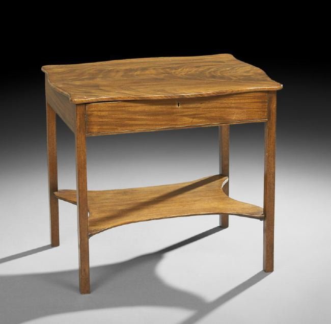 George III-Style Mahogany Dressing Table: George III-Style Mahogany Dressing Table, the shaped rectangular top hinged and opening to a variety of hinged compartments and central storage, raised above a concave stretcher shelf on square legs, 