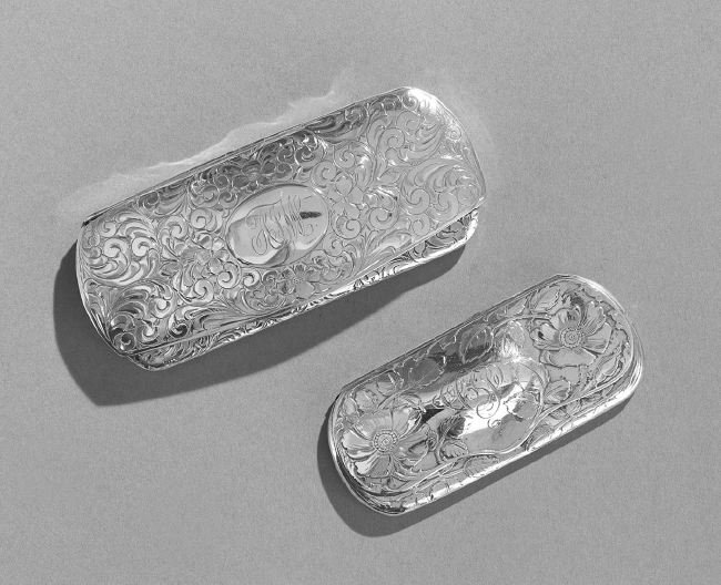 Two Art Nouveau Sterling Silver Eyeglass Cases: Two American Art Nouveau Sterling Silver Eyeglass Cases, first quarter 20th century, including a La Secla, Fried & Co. example with floral and scroll engraving, monogrammed "AIW", l. 5"; and a Clarenc