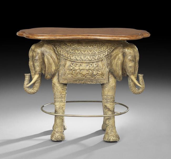 Whimsical Composition and Iron Tall Table: Whimsical Composition and Iron Tall Table, of bar height, with a shaped top supported by a pedestal in the form of an elephant with two opposing heads, the legs joined by a metal foot rail, h. 43", w.