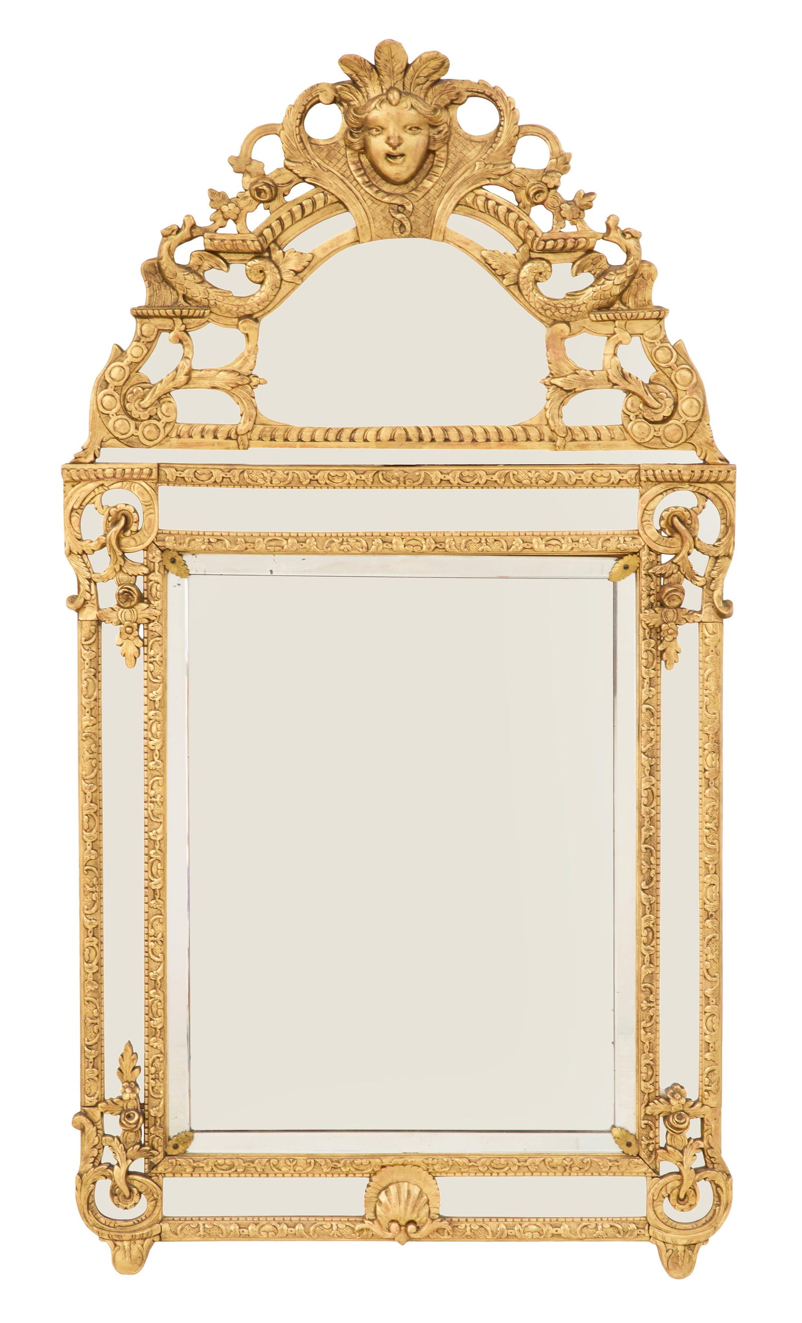 French Giltwood Mirror in the Regency Taste: French Giltwood Mirror in the Regency Taste 20th century, the mirror-backed pierced pediment decorated with a masque and a pair of dolphins accented with scrollwork and flower heads, the surround inse