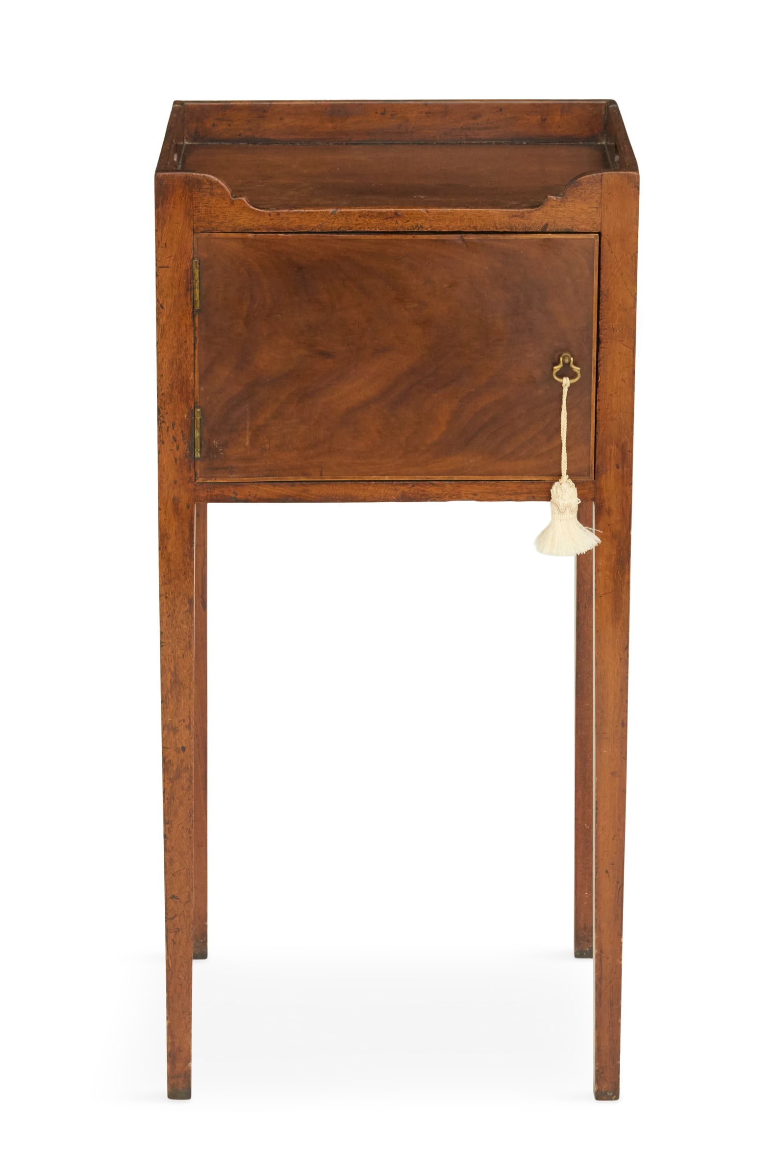 George III Mahogany Side Table: George III Mahogany Side Table 18th century, the top with a three-quarter raised gallery and scalloped front, the side ends with hand-grip cutouts, the front fitted with a cabinet door, raised on tape