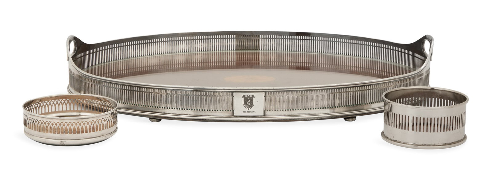Three Galleried Silverplate Table Pieces: Three Galleried Silverplate Table Pieces with Wood Bases second quarter 20th century, including: a tea tray, oval with inlaid patera and protective glass insert, engraved with the logo of the Bryson