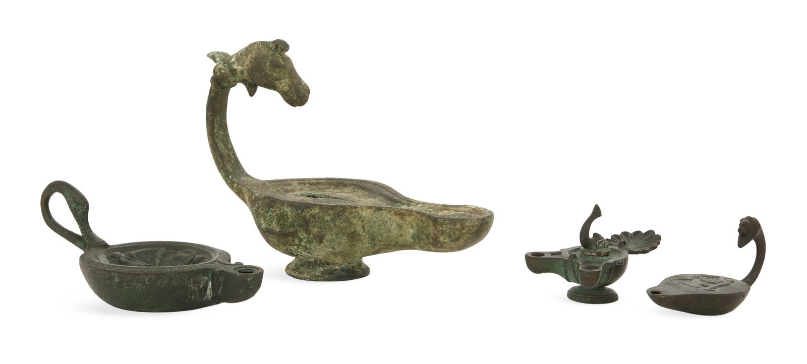Four Grand Tour Bronze Oil Lamps: Four Grand Tour Bronze Oil Lamps the largest a heavily patinated example with a horse-head handle, h. 6", w. 7-3/4", d. 3-1/2", 19th century or earlier, together with three smaller patinated bronze la