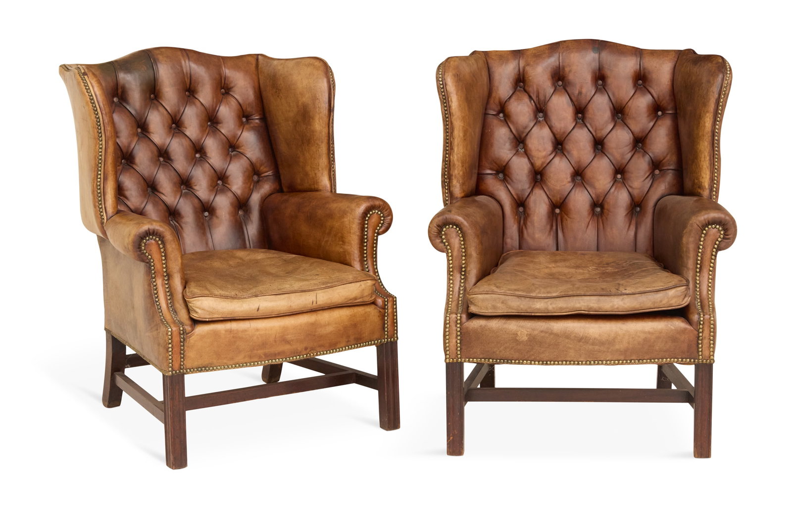 Pair of Leather Wing Chairs: Pair of Leather Wing Chairs 20th century, in the George III taste, of traditional form, each chair with a diamond-tufted back and loose seat cushion, raised on Marlborough legs joined by stretchers. h