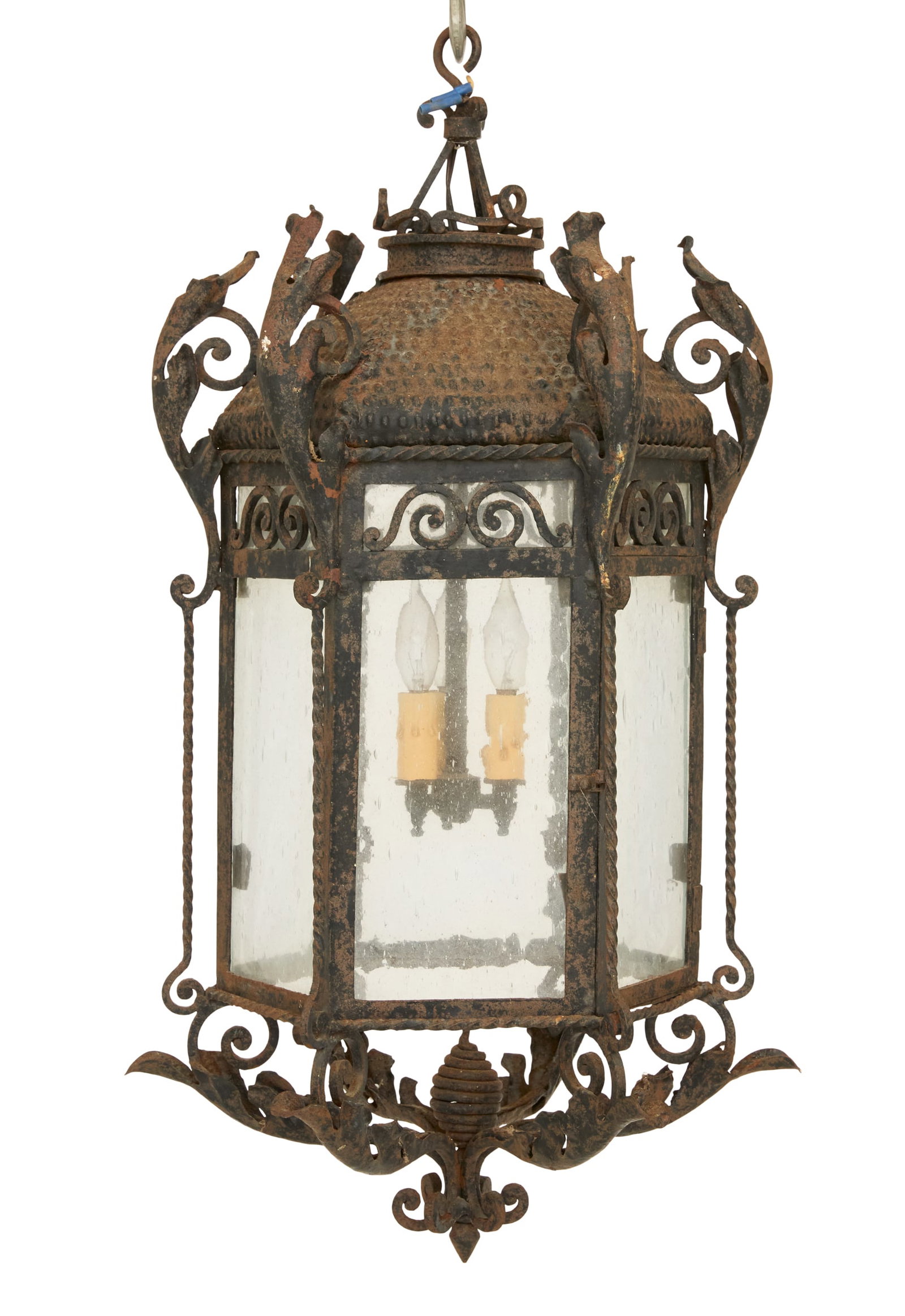 Wrought-Iron and Stamped Metal Pendant Lantern: Wrought-Iron and Stamped Metal Pendant Lantern early 20th century, in the Spanish Colonial taste, of hexagonal form, with a domed top and leaf-form brackets, the six sides set with hand-blown glass pa