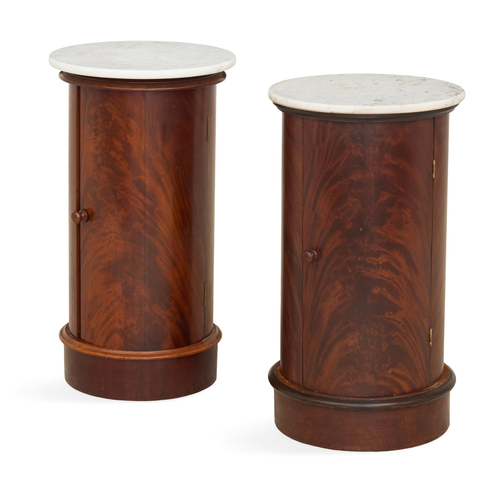 Two Regency Mahogany Barrel-Form Pot Cabinets: Two Regency Mahogany Barrel-Form Pot Cabinets 19th century, each with a circular white marble top over a highly figured and curved door, opening to an interior with a central shelf. h. 29-1/2", dia. 1