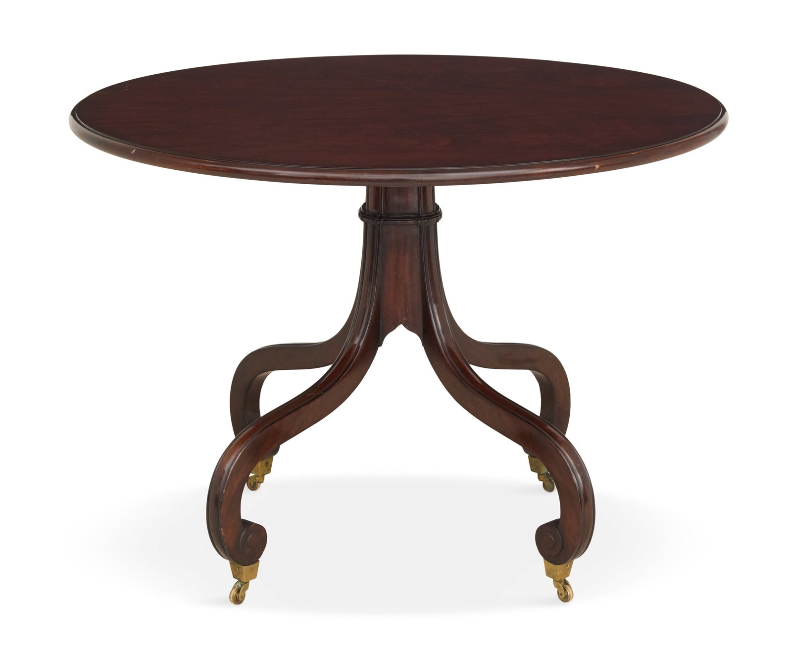 Regency Mahogany Center Table: Regency Mahogany Center Table 19th century, the circular top mounted to a central standard with four down-curved and scrolled legs ending in brass cup casters. h. 30", dia. 42"
