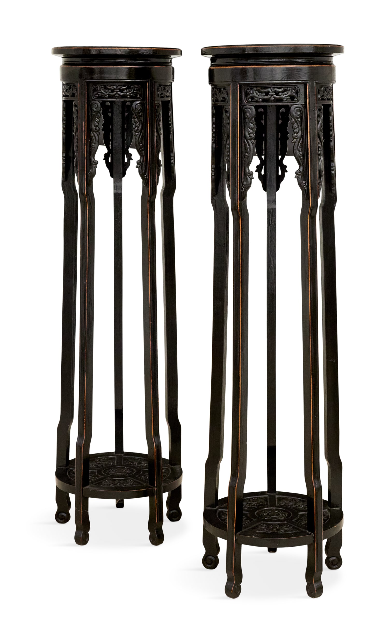 Pair of Chinese Ebonized Wood Torchere Stands: Pair of Chinese Ebonized Wood Torchere Stands the molded legs decorated with pierced skirts, the side panels carved with scrollwork, the circular, bas-relief-carved base shelves with panels of flowers