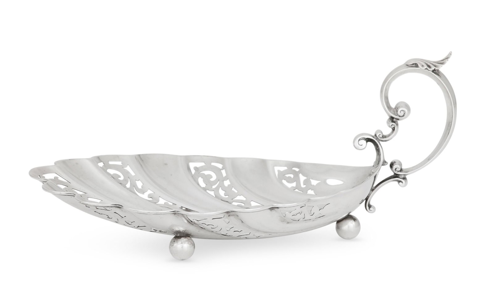 American Sterling Reticulated Coquille Dish: American Sterling Silver Reticulated Coquille Dish mid-20th century, the lobes alternately decorated with openwork scrolls, with a shell-crested, treble "C"-scroll handle and three spherical feet. h. 