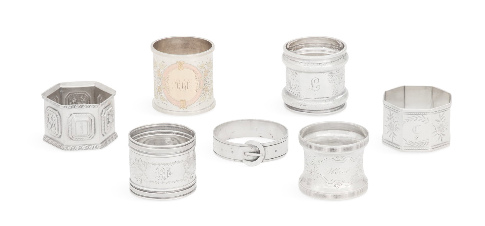 Seven American Silver Napkin Rings: Seven American Silver Napkin Rings late 19th/early 20th century, round except where noted, including: one with torus banding and decorated with wrigglework and bright-cut flowers, monogrammed "T", h. 