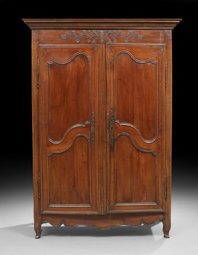 French Provincial Fruitwood Armoire: French Provincial Fruitwood Armoire, early 19th century, the rounded and molded rectangular cornice above a conforming case fitted with a foliate-carved frieze over two bi-paneled doors, over a shaped