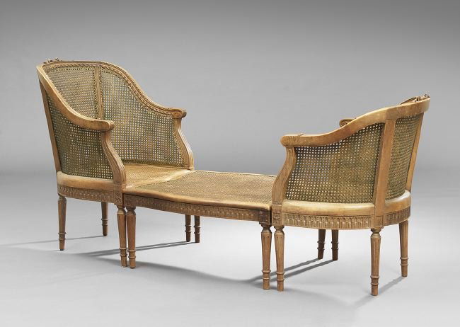 Provincial Louis XVI-Style Duchesse Brisee: Provincial Louis XVI-Style Fruitwood Duchesse Brisee, early 20th century, in three sections, the domed and trisected caned back surmounted by an annulated and ribbon frame, joined by carved sides to t