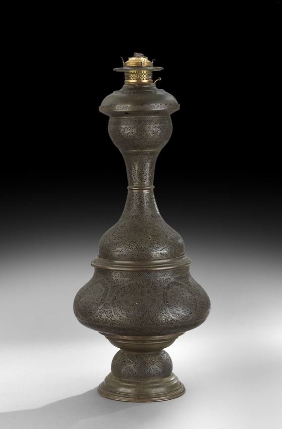 Middle Eastern Pierced Brass Banquet Lamp: Middle Eastern Pierced Brass Banquet Lamp, fourth quarter 19th century, the standard pierced in stars, point arches and calligraphy, and set with a kerosene burning font, h. 32-1/2", dia. 10-3/4".