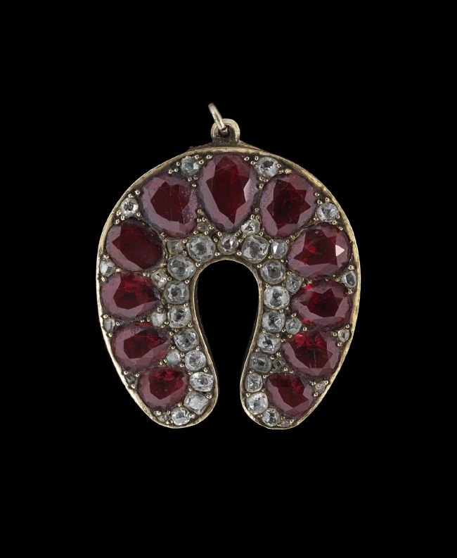 Victorian 14 Kt. Gold and Garnet Horseshoe Brooch: Victorian Fourteen-Karat Yellow Gold, Diamond and Garnet Horseshoe Brooch/Pendant, the brooch set with twenty-eight old mine-cut diamond melees and fourteen rose-cut diamond melees, with a total appro