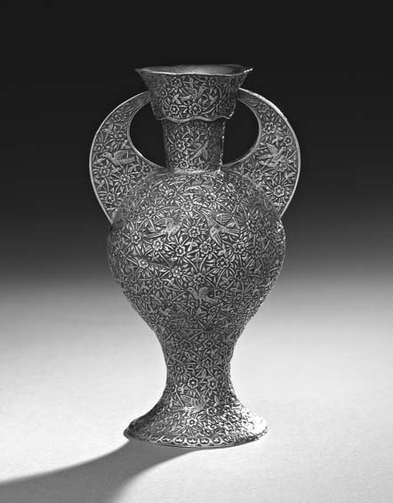 English Colonial Silver Vase: English Colonial Silver Vase, first half 20th century, Indian or East Asian, the inverted pear-shaped body with integral foot and cylindrical neck, with wavy rim and crescent-shaped handles, decorated