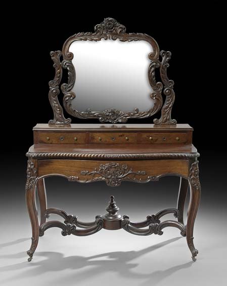 American Rococo Revival Mahogany Dressing Table: American Rococo Revival Mahogany Dressing Table, mid-19th century, the mirror plate surmounted by a floral-carved crest and supported by foliate supports on a shallow band of drawers, the serpentine t