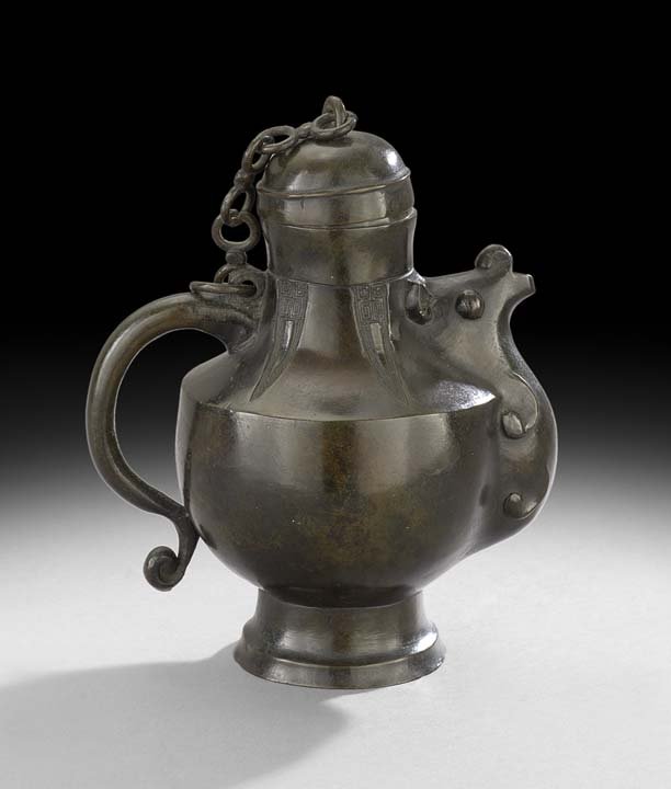 Chinese Bronze Ewer: Chinese Bronze Ewer, 18th century, with an animal-form spout and archaic-style cicada motifs, the cover chained to the handle, h. 7", l. 6".