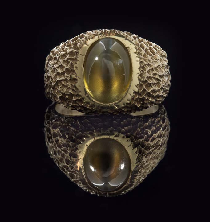 14 Kt. Yellow Gold and Cat's Eye Ring: Fourteen-Karat Yellow Gold and Cat's Eye Ring, the nugget-style ring set with an oval-shaped cabochon cat's eye, with an approximate total weight of 6.92 carats, size 9-3/4, 13.0 grams total weight.
