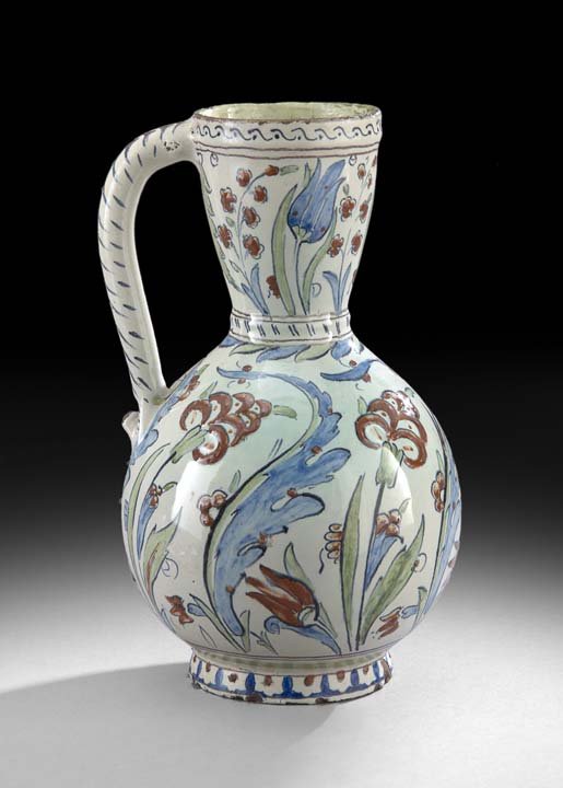 Persian Tin-Glazed Redware Ewer: Persian Tin-Glazed Redware Ewer, decorated with swirling leaves and flowers on a white ground, trimmed in blue, h. 10-1/2", dia. 5-1/2".