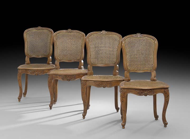 Four Provincial Louis XV Fruitwood Sidechairs: Suite of Four Provincial Louis XV Fruitwood Sidechairs, mid-18th century, each with a shell-carved crest above a caned back, the cushioned caned seat raised above a foliate shell apron on cabriole leg