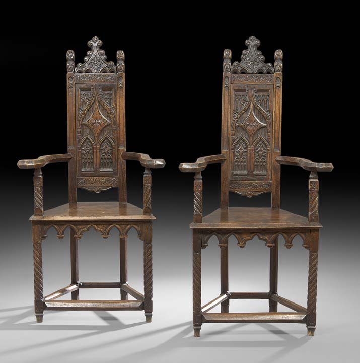 Pair of Continental Gothic-Style Walnut Armchairs: Pair of Continental Gothic-Style Walnut Armchairs, 19th century, each with a shaped crest and crocket finials above a narrow paneled back with Gothic arch carving, joined by outscrolled arms to the cu