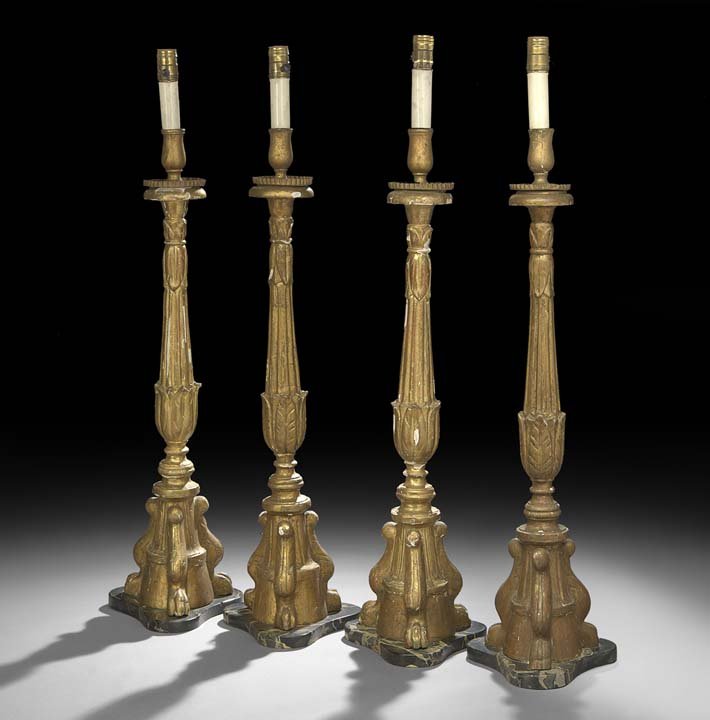 Set of Four Italian Giltwood Altar Sticks: Set of Four Italian Giltwood Altar Sticks, second quarter 19th century, now on Egyptian marble bases, of tripartite form, on carved paw feet, the standards leaf-molded and fluted, electrified, h. 34",