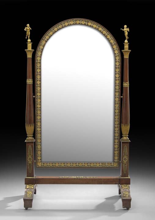 Empire-Style Mahogany Cheval Mirror: Empire Mahogany Cheval Mirror, second quarter 19th century, the domed mirror plate within a frame with applied ormolu grapevine mounts, and supported by bulbous columns surmounted by winged putti on s