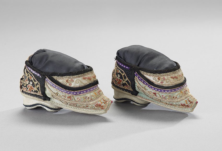 Pair of Chinese Lotus Shoes: Pair of Chinese Lotus Shoes, 19th century, each silk and cotton slipper colorfully and elaborately embroidered with a floral motif and a design of beautiful women on the ankles, a Buddhist symbol on t