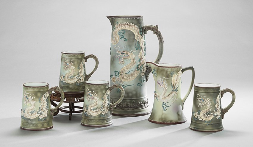 Six Pieces of Japanese Nippon Ware: Six Pieces of Japanese Nippon Ware, 20th century, including a large pitcher, h. 13-3/4", a small pitcher, h. 8-1/2", and four mugs adorned with winged dragons, with maroon-rimmed lips and bases, and h