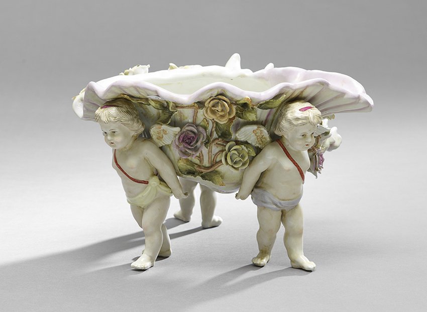 Meissen-Style Shell-Form Bowl: Meissen-Style Shell-Form Bowl, first quarter 20th century, decorated with encrusted flowers on cherub supports, with a spurious crossed sword over R mark, h. 8-3/4", w. 14", d. 12".