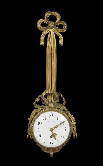French Gilt-Bronze Wall Clock: French Gilt-Bronze Wall Clock, ca. 1900, in the Louis XVI style, retailed by Black, Starr and Frost, in a round case held by a bronze bowknot, the dial signed by the retailer and "France", h. 30", w. 