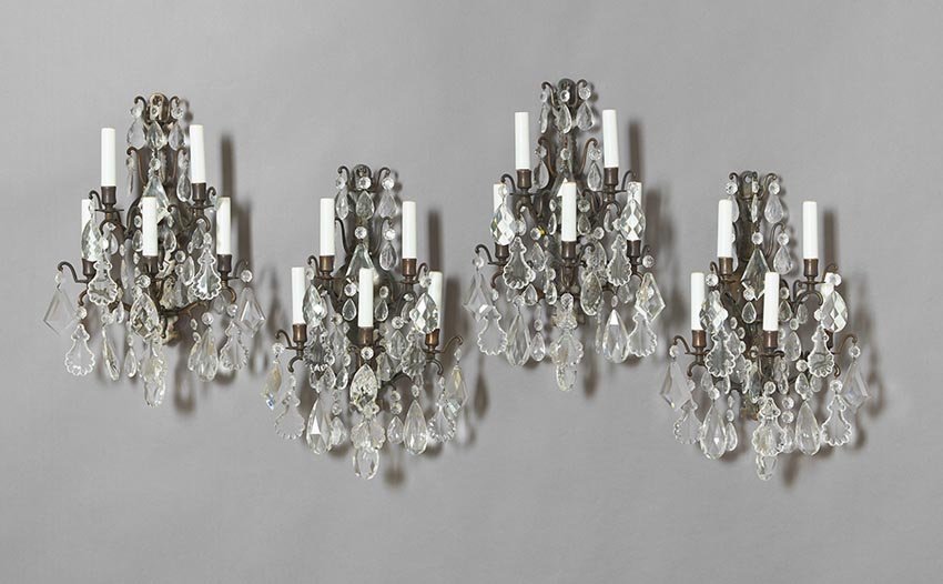 Four Louis XV-Style Bronze and Cut Glass Sconces: Set of Four Matching Louis XV-Style Bronze and Cut Glass Five-Light Sconces, the circular backplates holding sprays of flowers, the whole elaborately dressed with cut glass beads and prisms, h. 18", w