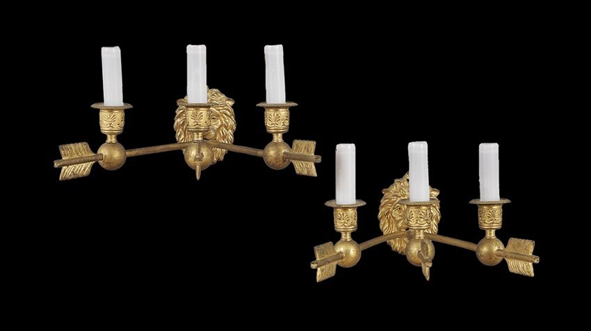 Pair of French Empire-Style Gilt-Bronze Sconces: Pair of French Empire-Style Gilt-Bronze Sconces, early 20th century, the arrow-form branches emanating from lion's head backplates, the engine-turned and anthemion-molded candle cups fitted for electr