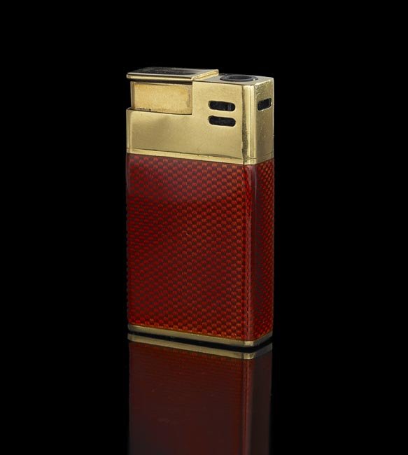 18 Kt. Gold and Enamel Bulgari Cigarette Lighter: Eighteen-Karat Yellow Gold and Enamel Bulgari Cigarette Lighter, the reddish-rust colored guilloche enamel gas lighter marked "BVLGARI, 750, ITALY 18KT", the lighter activated by the plunger, h. 2-1/4