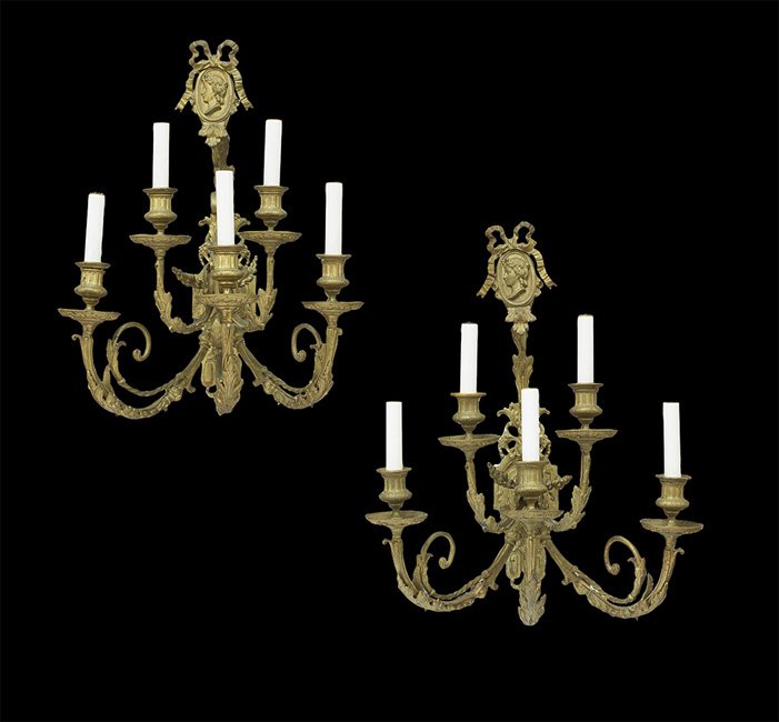 Pair of French Belle Epoque Bronze Sconces: Pair of French Belle Epoque Bronze Sconces in the Baroque Taste, fourth quarter 19th century, each molded backplate with a neoclassical profile portrait crest, and Louis XIV-style scrolled and leaf-mo