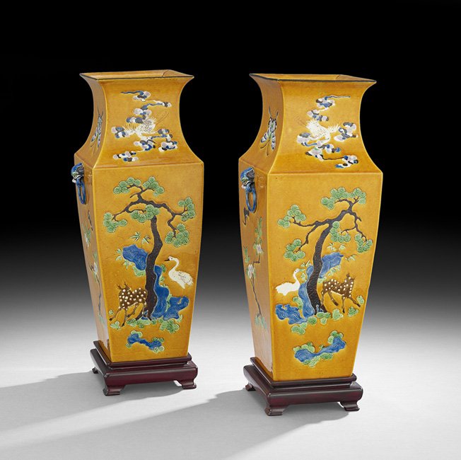 Pair of Chinese Ochre-Ground Vases on Stands: Pair of Chinese Ochre-Ground Vases on Stands, 19th/20th century, the squared vases with blue foo dog lugs, the necks decorated with two butterflies, a phoenix among clouds and an iris, the bodies depi