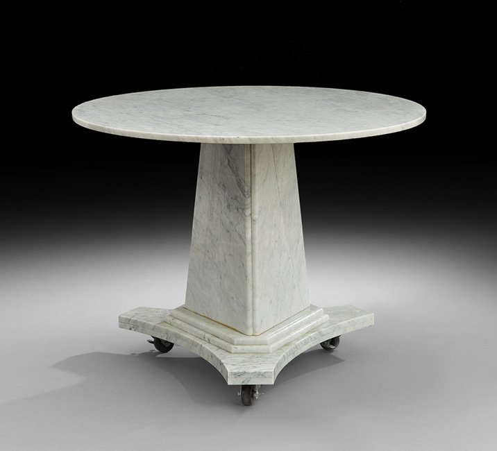 Carrara Marble Gueridon: Carrara Marble Gueridon, the circular top raised on a graduated concave tripartite standard to a conforming molded base on casters, h. 30-1/4", dia. 41-1/2". This table is a reproduction of a table pu