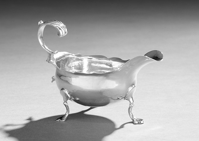 George III Hester Bateman Silver Cream Boat: George III Hester Bateman Sterling Silver Cream Boat, hallmarked London, 1783-1784, of traditional bulbous oval form, with everted spout, scalloped rim, crested double "C"-scroll handle and raised on