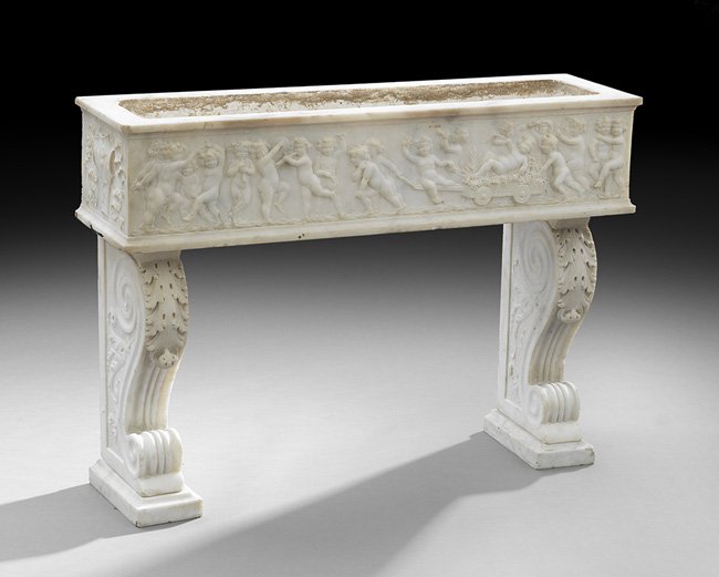 Italian Neoclassical-Style Carved Marble Planter: Italian Neoclassical-Style Carved Marble Planter, ca. 1900, the leaf-carved corbel-form base supporting the rectangular planter box, the front with putti enjoying a Dionysian fete, with carved crests